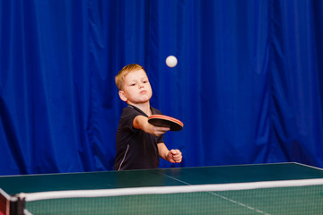 a boy seven years playing table tennis