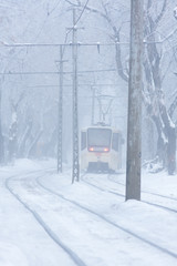 the tram goes on rails in the winter evening
