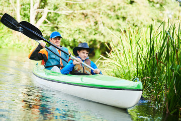 Kayaking on river in forest. Family on canoe. Active recreation and vacation