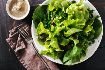 Plate fresh green salad flax seeds dark wooden background Diet food