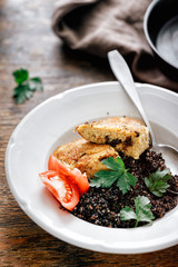 Dinner table Fried prunes oat cutlets black quinoa plate on wooden table