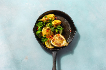 pan fried Brussels sprouts zucchini blue stone background top view