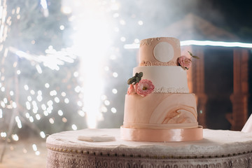 Wedding Cake on a table on  background of evening salutes
