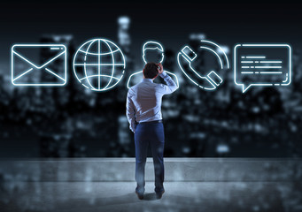 Businessman watching contact icon on the top of a building