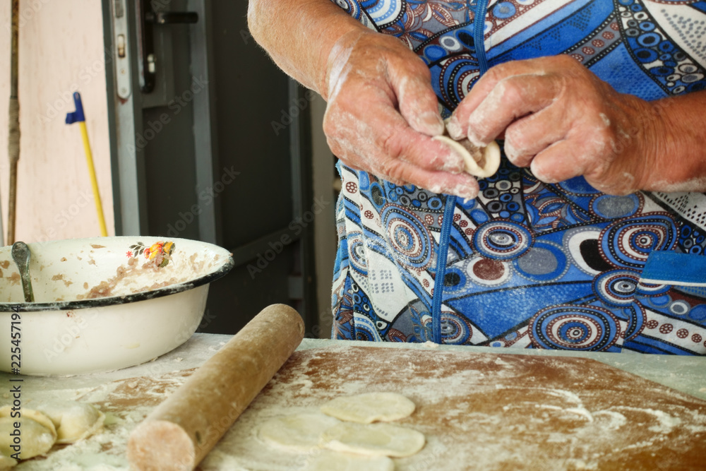 Wall mural Home-made recipe for dumplings (raviol)i. Traditionally, women of the older generation mold the dumplings in the family.