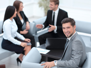 businessman sitting in an office on the background of business team.