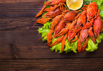 tasty red lobsters and crayfish on wooden background