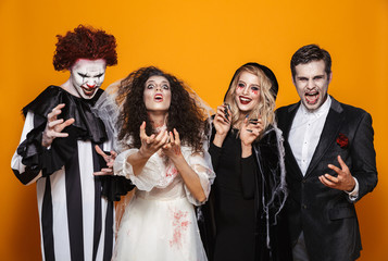 Group of smiling friends dressed in scary costumes