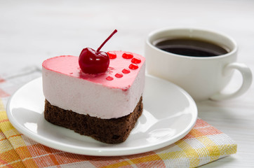 souffle cake in the form of heart  with cup of coffe  on a wooden table