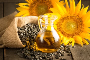 Rolgordijnen Closeup photo of sunflower oil with seeds on wooden background. Bio and organic product concept. © xander21