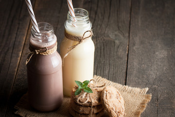 Photo of fresh Made Chocolate Banana Smoothie on a wooden table with cookies, banana and coconut. Milkshake. Protein diet. Healthy food concept. Drink, coffee beans, chocolate.