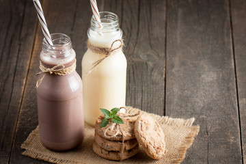 Photo of fresh Made Chocolate Banana Smoothie on a wooden table with cookies, banana and coconut. Milkshake. Protein diet. Healthy food concept. Drink, coffee beans, chocolate.
