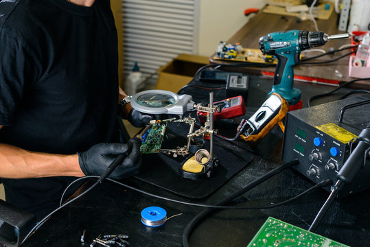 man solder a chip in a workshop close-up