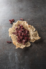 A pile of dried beef jerky pieces on paper and cutting board