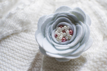 brooch in the form of a flower on a white sweater