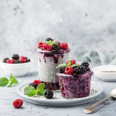 chia seeds pudding with berry sauce and fresh raspberry and blackberry in glass