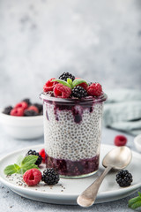 chia seeds pudding with berry sauce and fresh raspberry and blackberry in glass