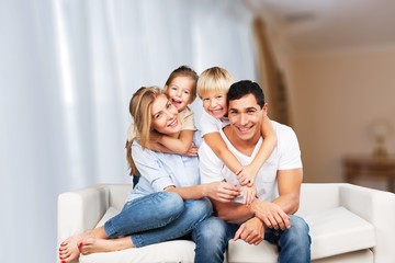 Fototapeta na wymiar Beautiful smiling family sitting at sofa at