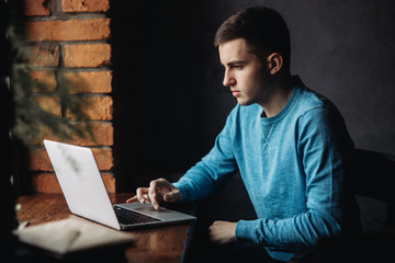 Young student programmer work at the cafe. He prepare for lesson