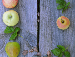 layout on a wooden background, apples, pears, small gravel stones, raspberry leaves