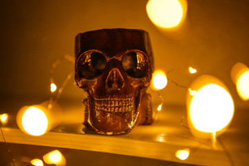 The figure of the skull burns with yellow light. Yellow lights garland lights skull. Festive and creepy decoration for Halloween