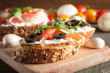 Italian tomato and cheese bruschetta. Tapas, antipasti with chopped vegetables, herbs and oil on grilled ciabatta and baguette bread.