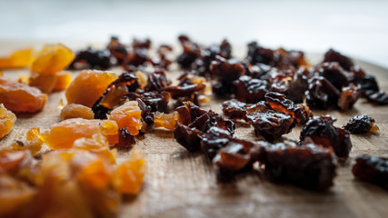 Healthy Diet Food Ingredients: Chopped Dried Apricots And Prunes On A Wooden Cutting Board.
