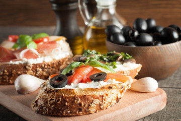 Italian tomato and cheese bruschetta. Tapas, antipasti with chopped vegetables, herbs and oil on grilled ciabatta and baguette bread.