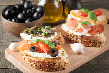 Italian tomato and cheese bruschetta. Tapas, antipasti with chopped vegetables, herbs and oil on grilled ciabatta and baguette bread.