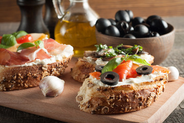Italian tomato and cheese bruschetta. Tapas, antipasti with chopped vegetables, herbs and oil on grilled ciabatta and baguette bread.