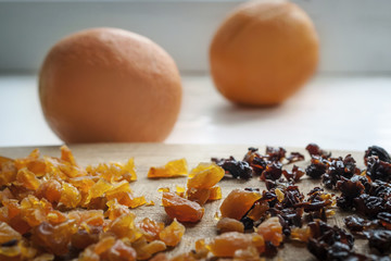 Healthy Diet Food Ingredients: Chopped Dried Apricots And Prunes On A Wooden Cutting Board. Oranges In The Background.