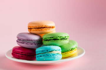 Still life and food photo of cake macarons in a gift box with flowers, a cup of tea on light background. Sweets and desserts concept of macaroons.