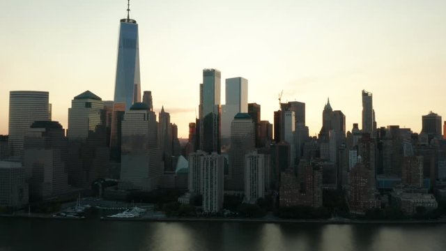 dawn sun peeks through as camera flies north along westside of downtown Manhattan