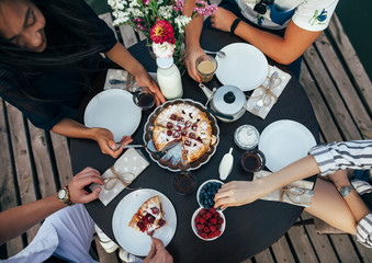 Top view of happy friends eating pie together