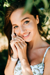 Closeup emotional  lifestyle portrait of adorable cute beautiful young cheerful coquette girl with big natural lips and blue happy eyes outdoor at nature.  Cute attractive smiling teen face.