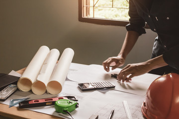 Concept architects, equipment architects On the desk with a blueprint in the office, Vintage, Sunset light.Selective Focus