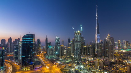 Fototapeta premium Dobai Downtown day to night timelapse. Aerial view over big futuristic city by night.