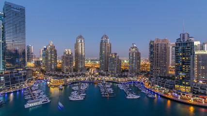 Fototapeta na wymiar Dubai Marina skyscrapers aeral day to night timelapse, port with luxury yachts and marina promenade