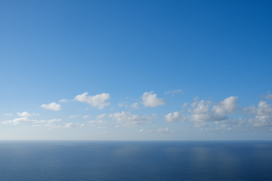  blue sky  above ocean horizon with clouds