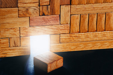 Glowing doorway in the construction of different wooden blocks. Concept of way to freedom