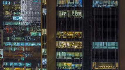 Fototapeta na wymiar Scenic glowing windows of skyscrapers at evening timelapse