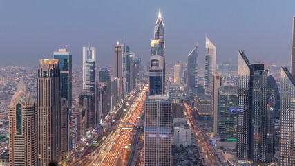 Fototapeta na wymiar Scenic Dubai downtown skyline day to night timelapse. Rooftop view of Sheikh Zayed road with numerous illuminated towers.