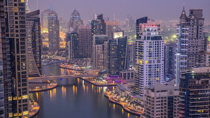 Naklejka premium Piękny widok z góry z lotu ptaka z dnia na noc przejście timelapse z kanału Dubai Marina