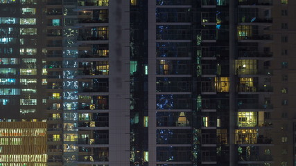 Glowing windows of skyscrapers at evening timelapse