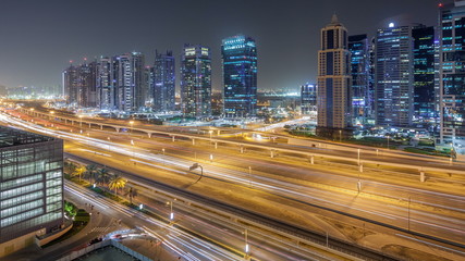 Fototapeta na wymiar Aerial view of Jumeirah lakes towers skyscrapers night timelapse with traffic on sheikh zayed road.