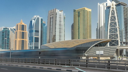 Fototapeta na wymiar View of Jumeirah lakes towers skyscrapers and metro sration timelapse with traffic on sheikh zayed road.