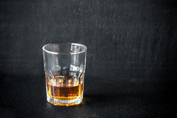 Glass of rum on the dark background