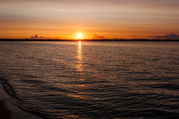 silhouette of a child on the background of the setting sun on the beach