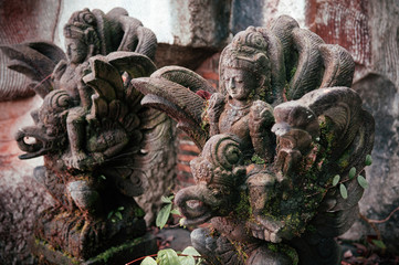 Traditional Balinese guard angel statue carved in dark stone close up