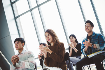 Obraz premium Young business people clapping hands during meeting in office for their success in business work